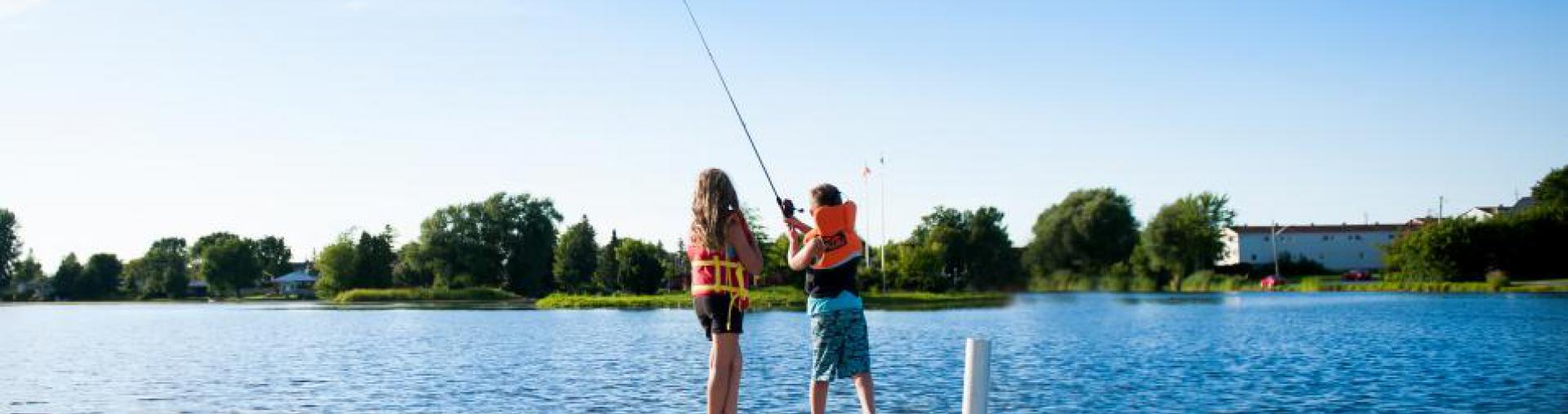 two kids fishing off of a dock