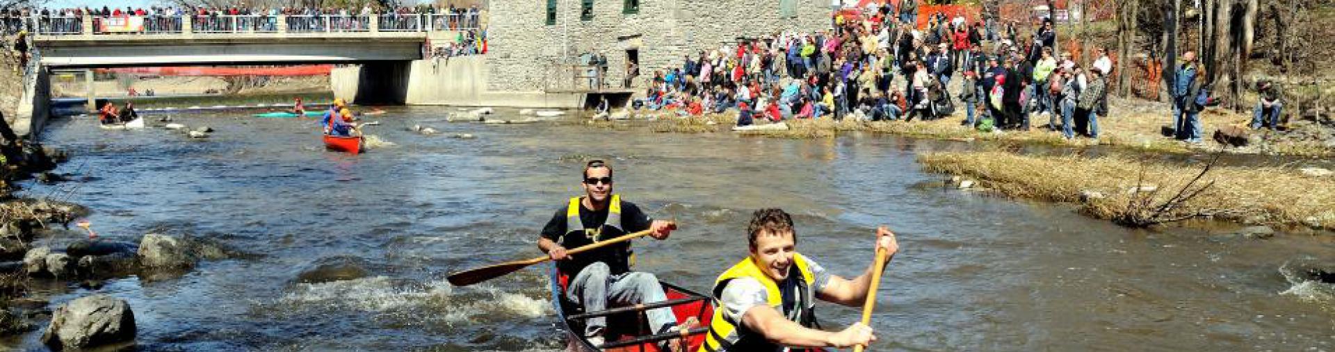 canoeists racing down Raisin River