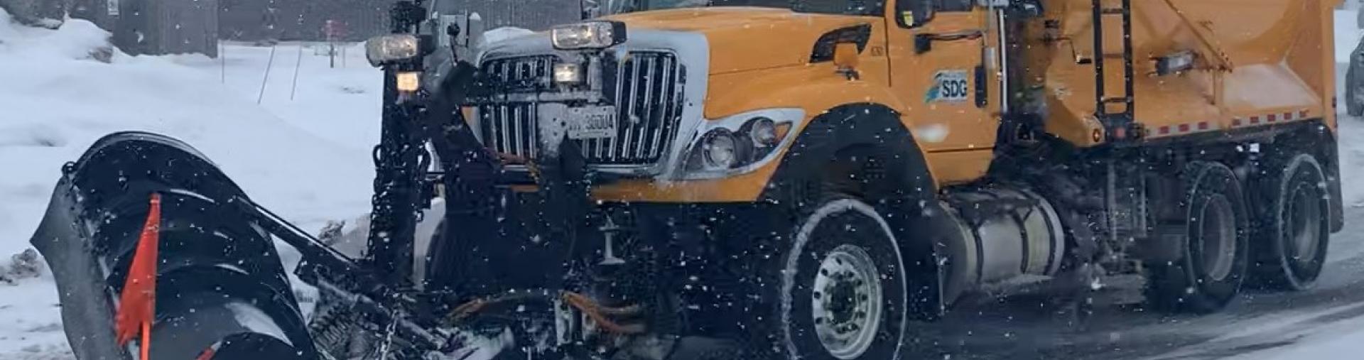 A snow plow on a County Road.