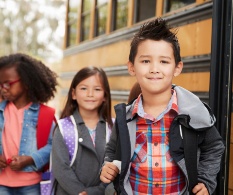 Children wait to enter a school bus.