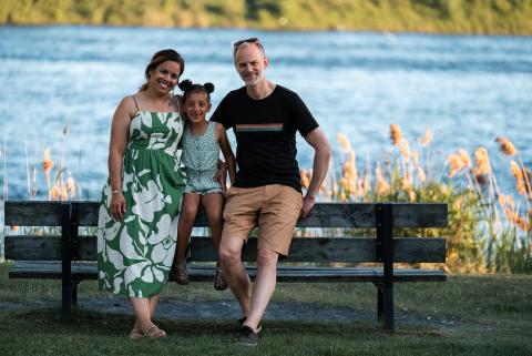 Family of 3 sitting in Lamoureux Park, Cornwall
